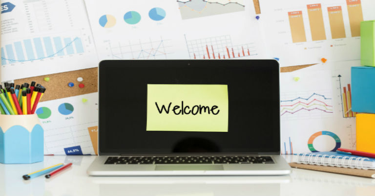 laptop with a sticky note that read welcome on the screen