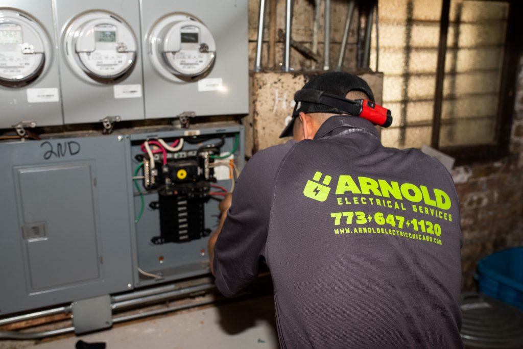 friendly electrician working on the circuit breaker inside a home