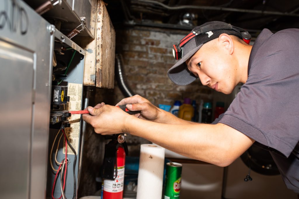 friendly electrician working on the circuit breaker inside a home