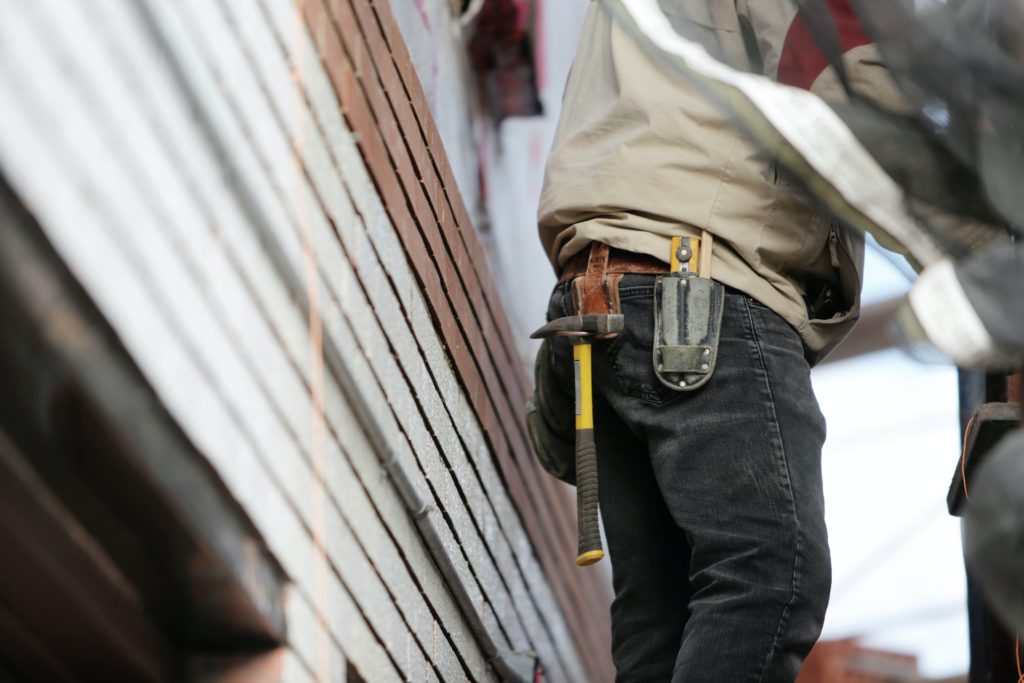 roofing technician wearing a toolbelt with a hammer